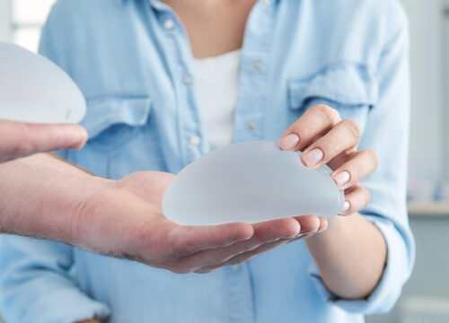 Photo of a plastic surgeon showing a female patient breast implants