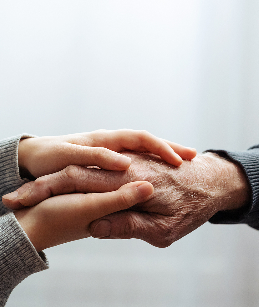 Photo of youthful hands holding an older person's hand