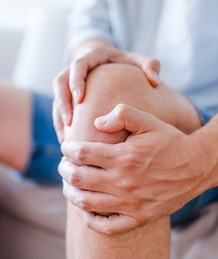 Photo of a man's hand clutching his knee