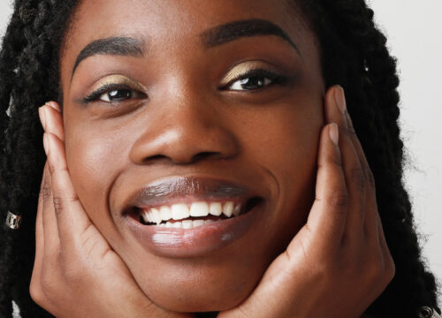 Photo of a smiling woman resting her chin in her hands